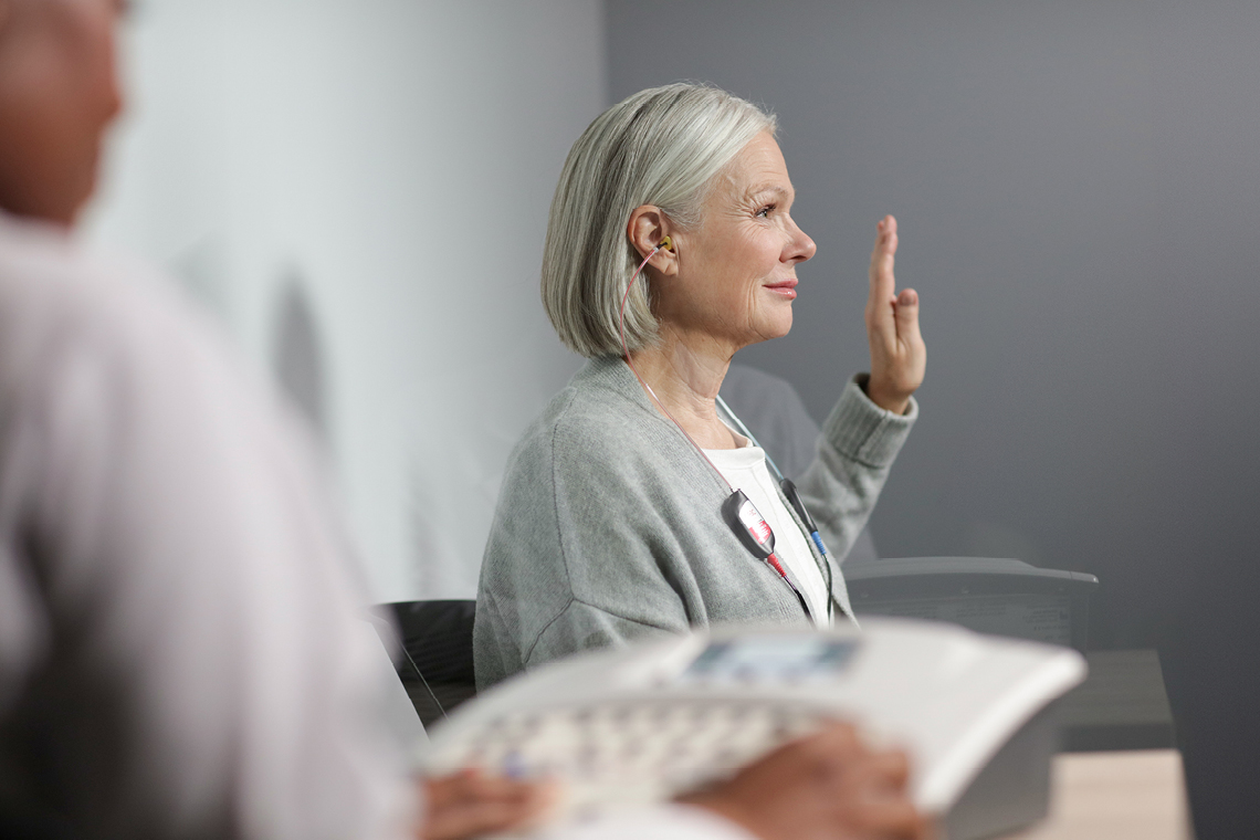 woman taking a hearing test with her arm in the air