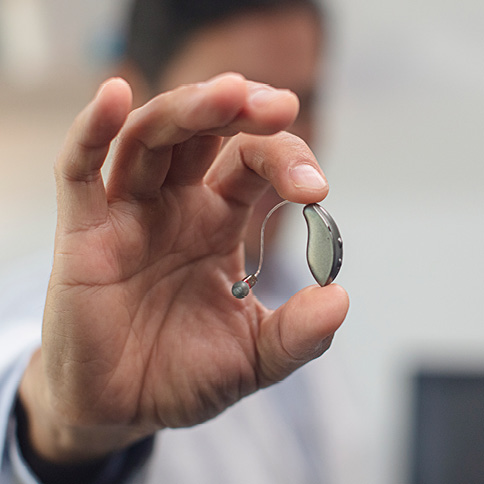 Small hearing aid in a mans hand