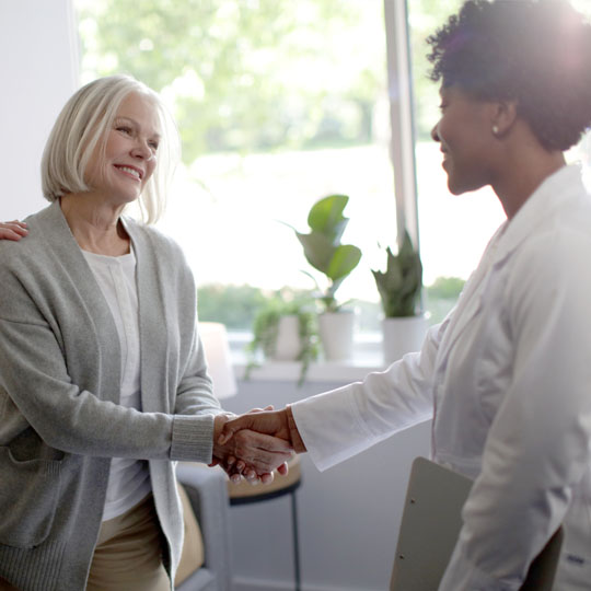 A woman shaking hands with a hearing professional
