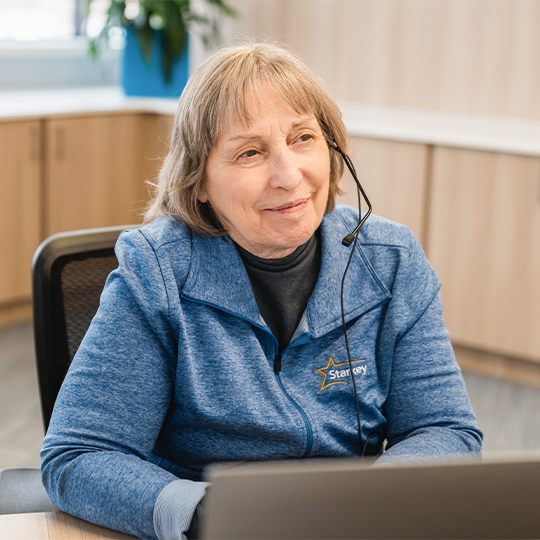 Professional answering phone at a computer