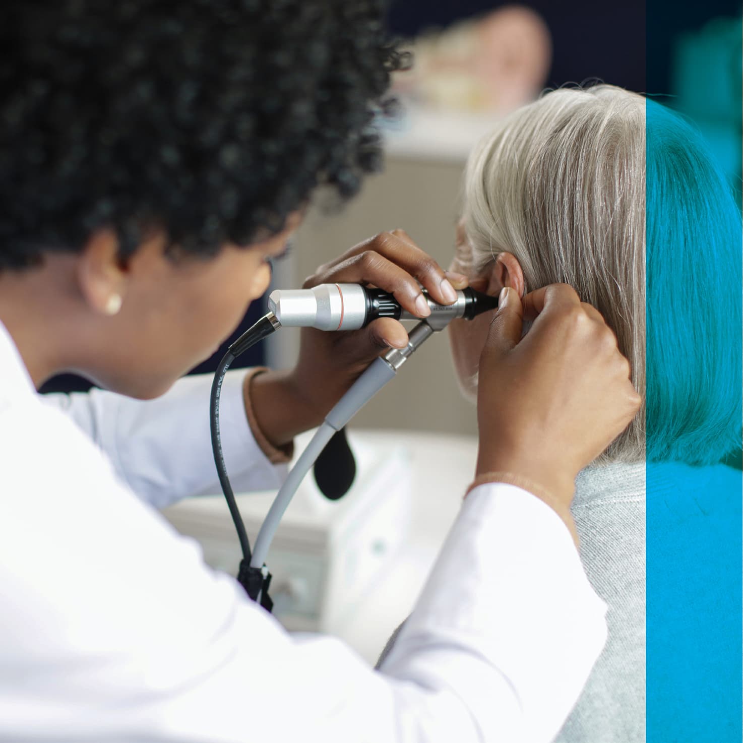 audiologist using an otoscope on a patient