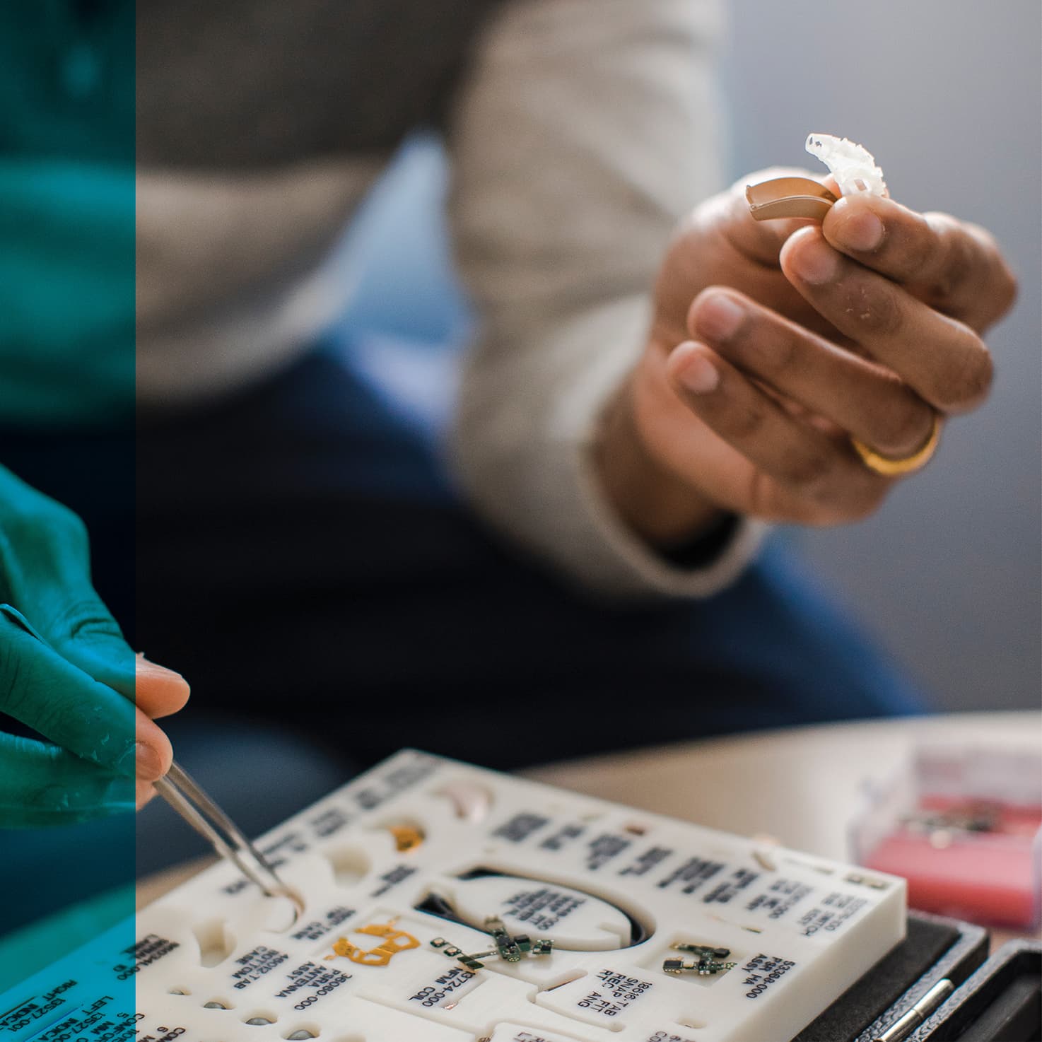 person's hands putting together a hearing aid with pieces from a set case