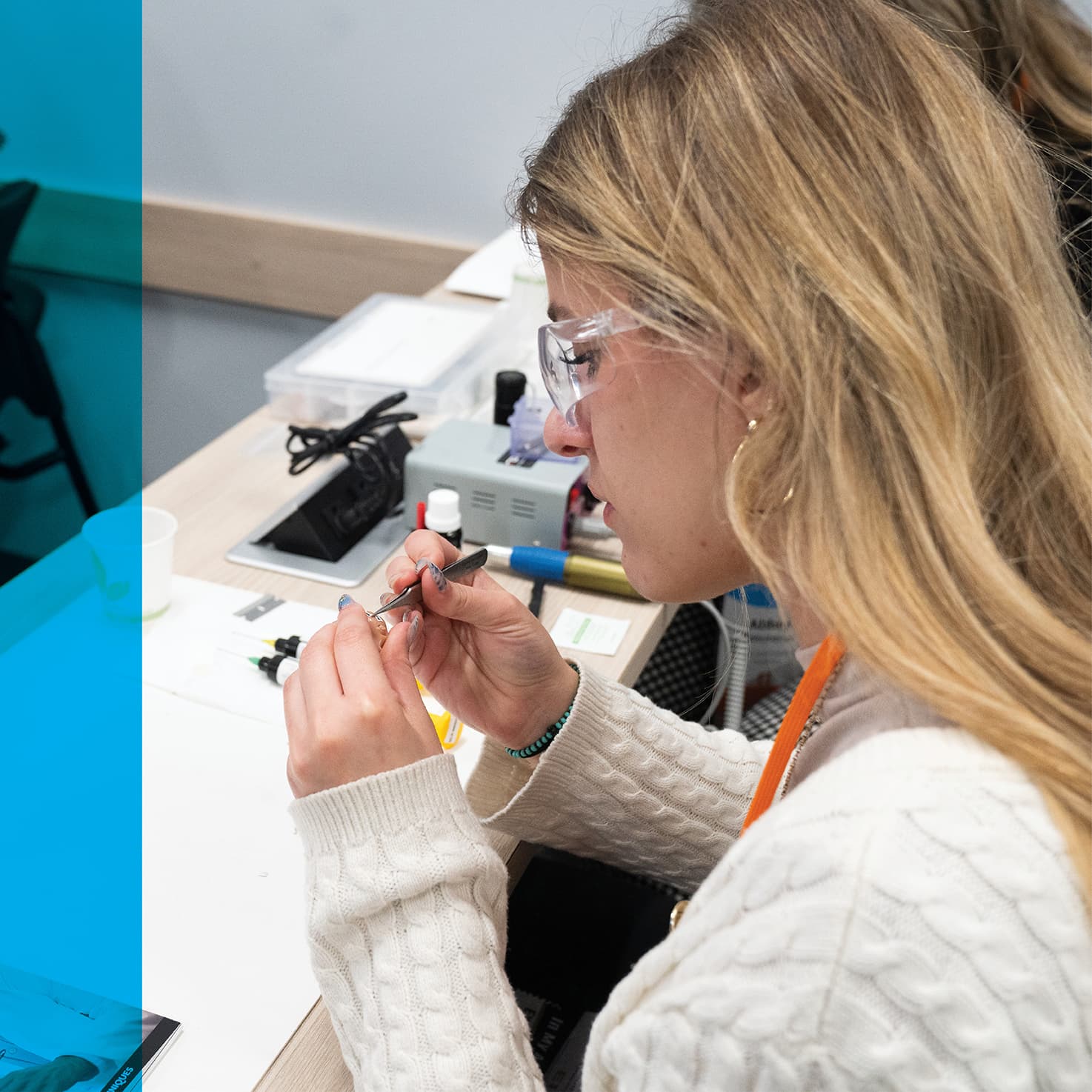 student at a lab desk fine tuning a hearing aid